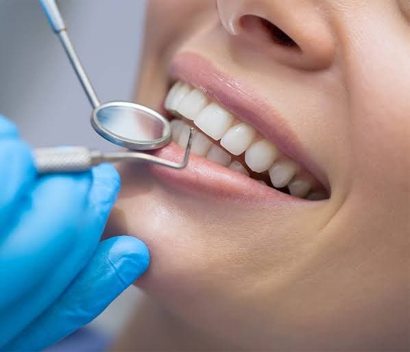 Dentist examining a patient's teeth before placing a tooth-colored composite filling